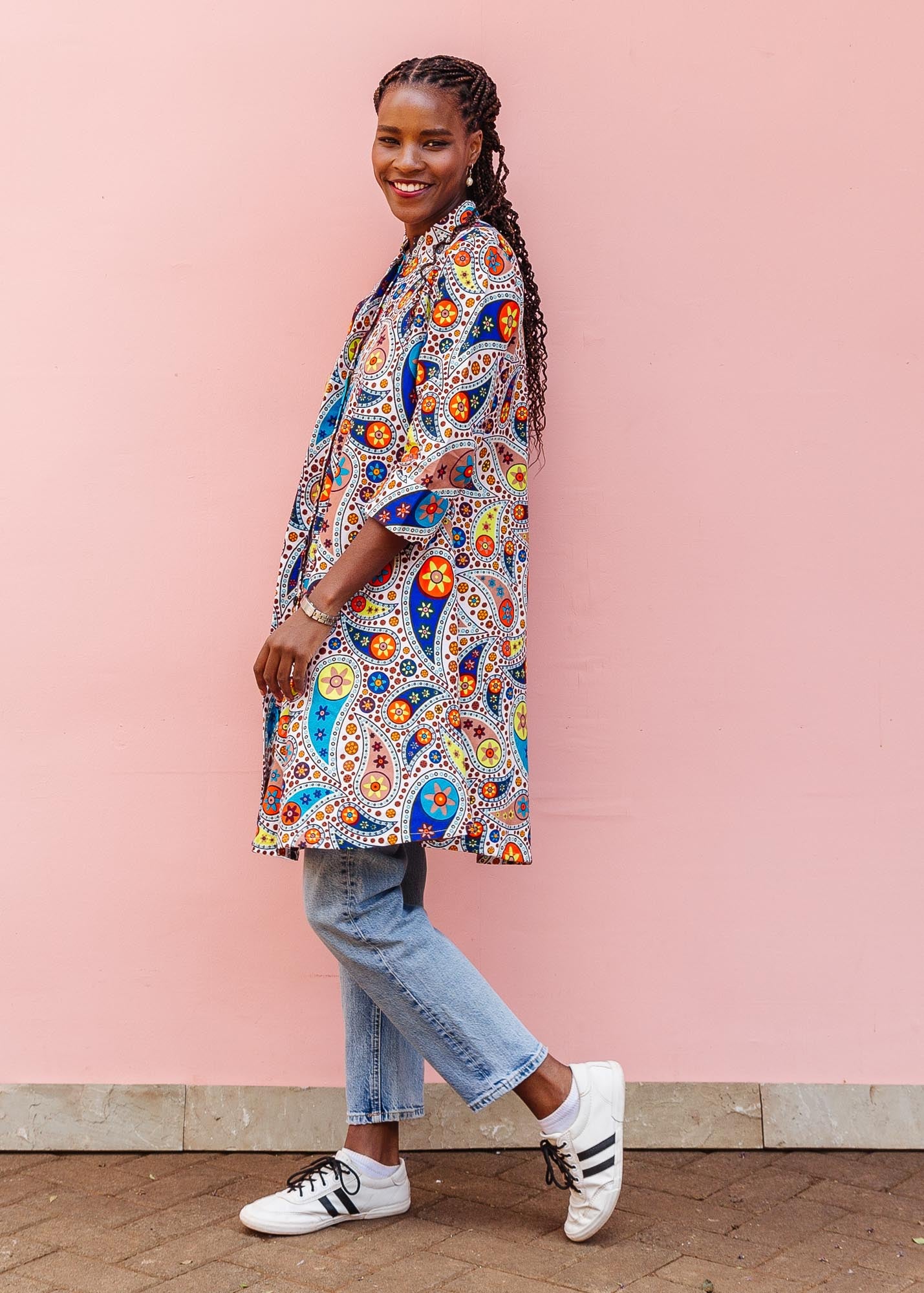 The model is wearing multi-colored paisley print dress