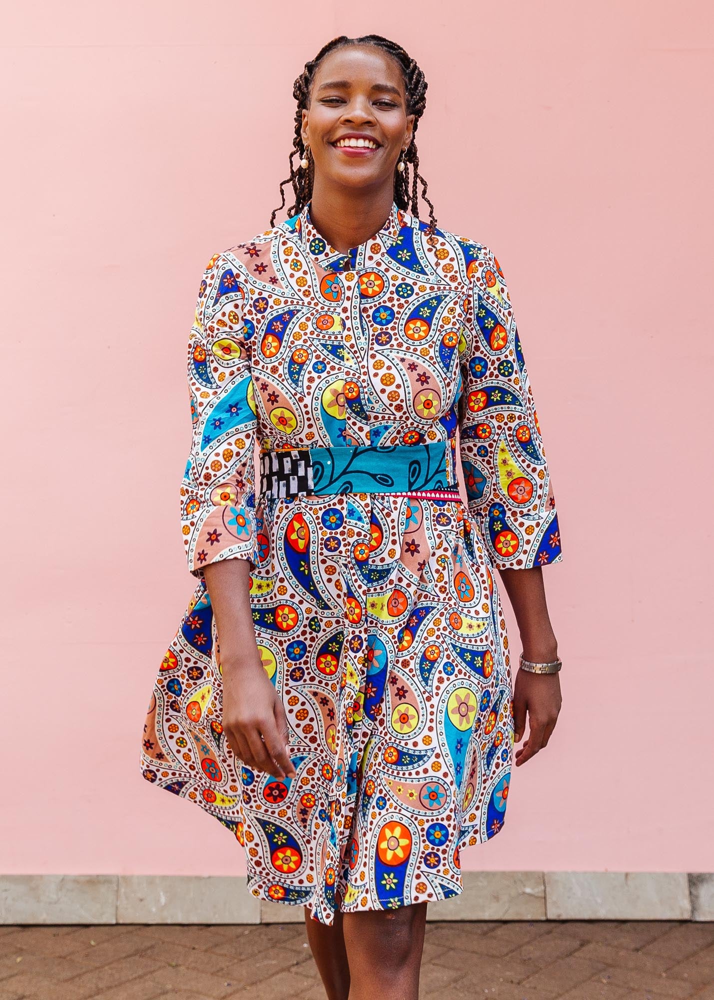 The model is wearing multi-colored paisley print dress