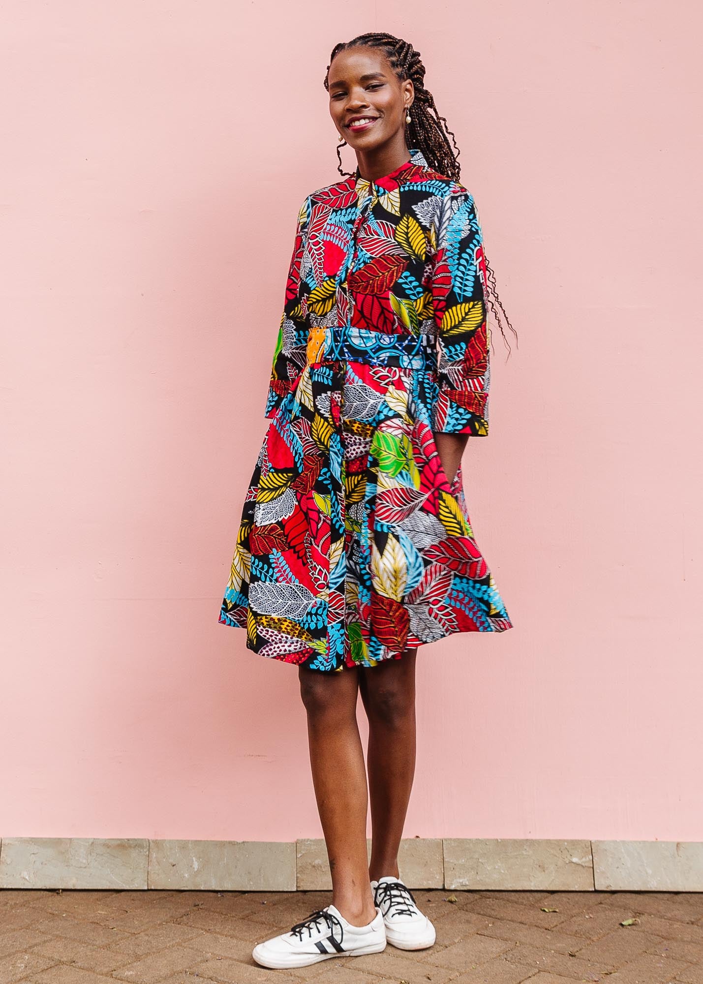 The model is wearing multi-colored leaf print dress