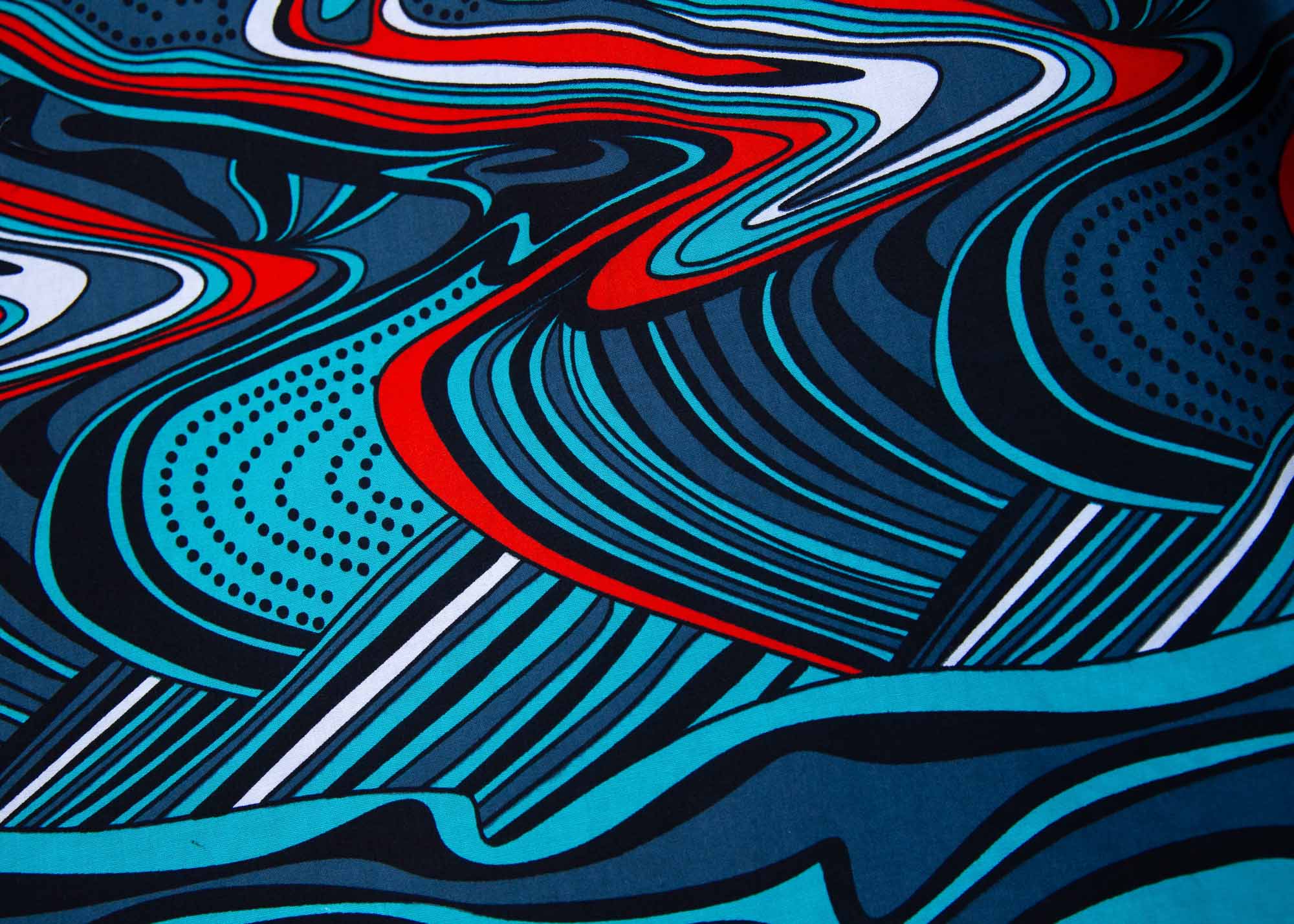 Close up display of turquoise, black, slate, white and red abstract print dress