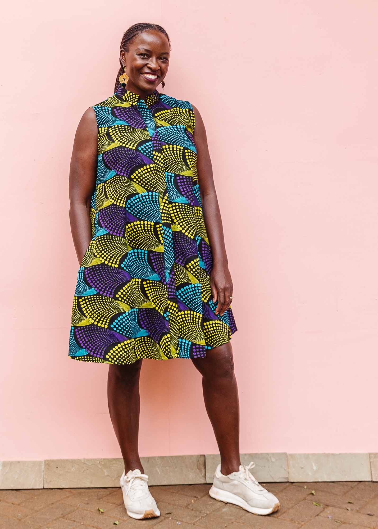 The model is wearing black dress with purple , yellow and turquoise dotted fans