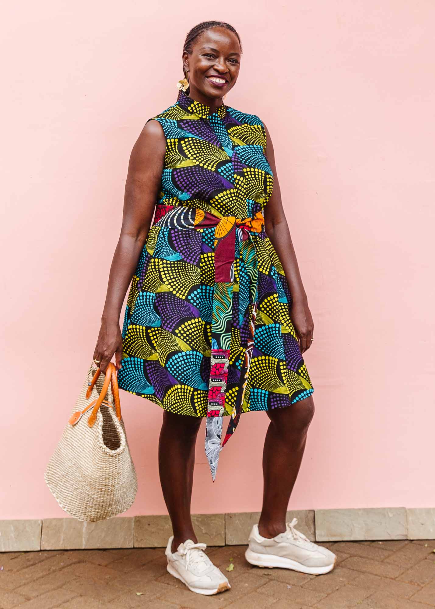 The model is wearing black dress with purple , yellow and turquoise dotted fans