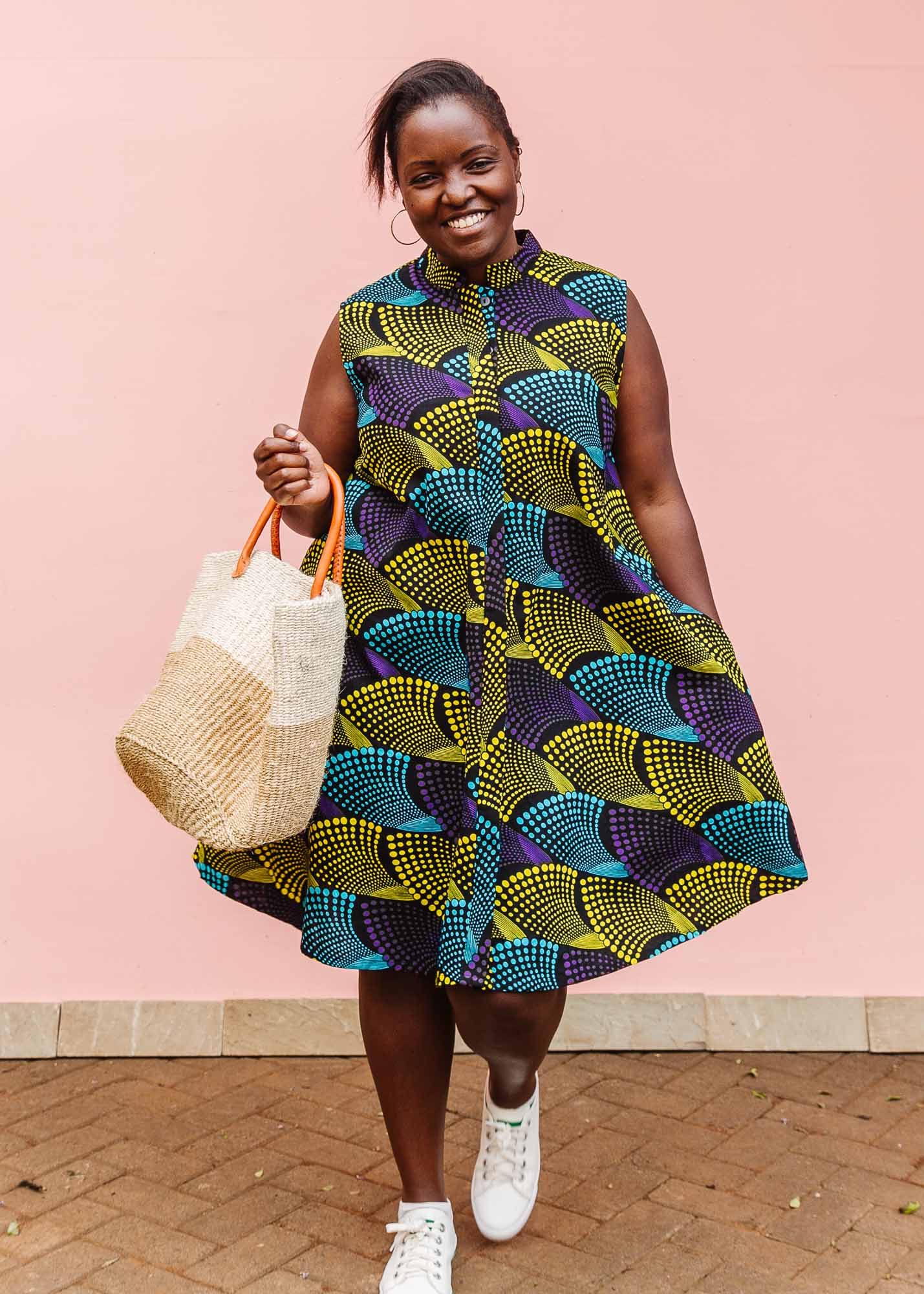 The model is wearing black dress with purple , yellow and turquoise dotted fans