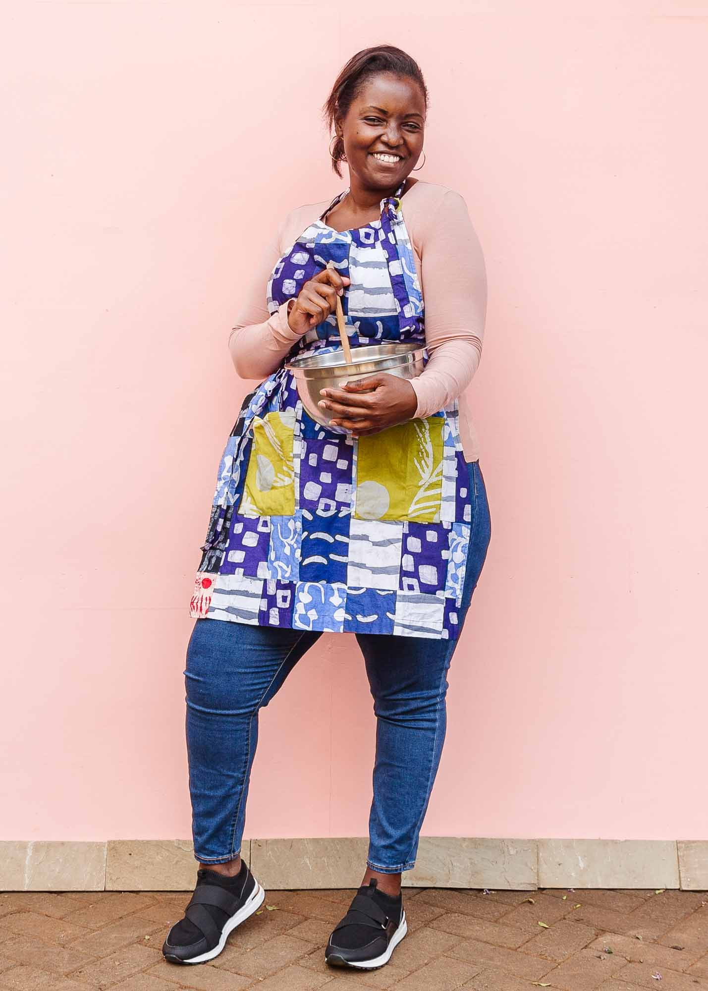 The model is wearing batik patchwork apron