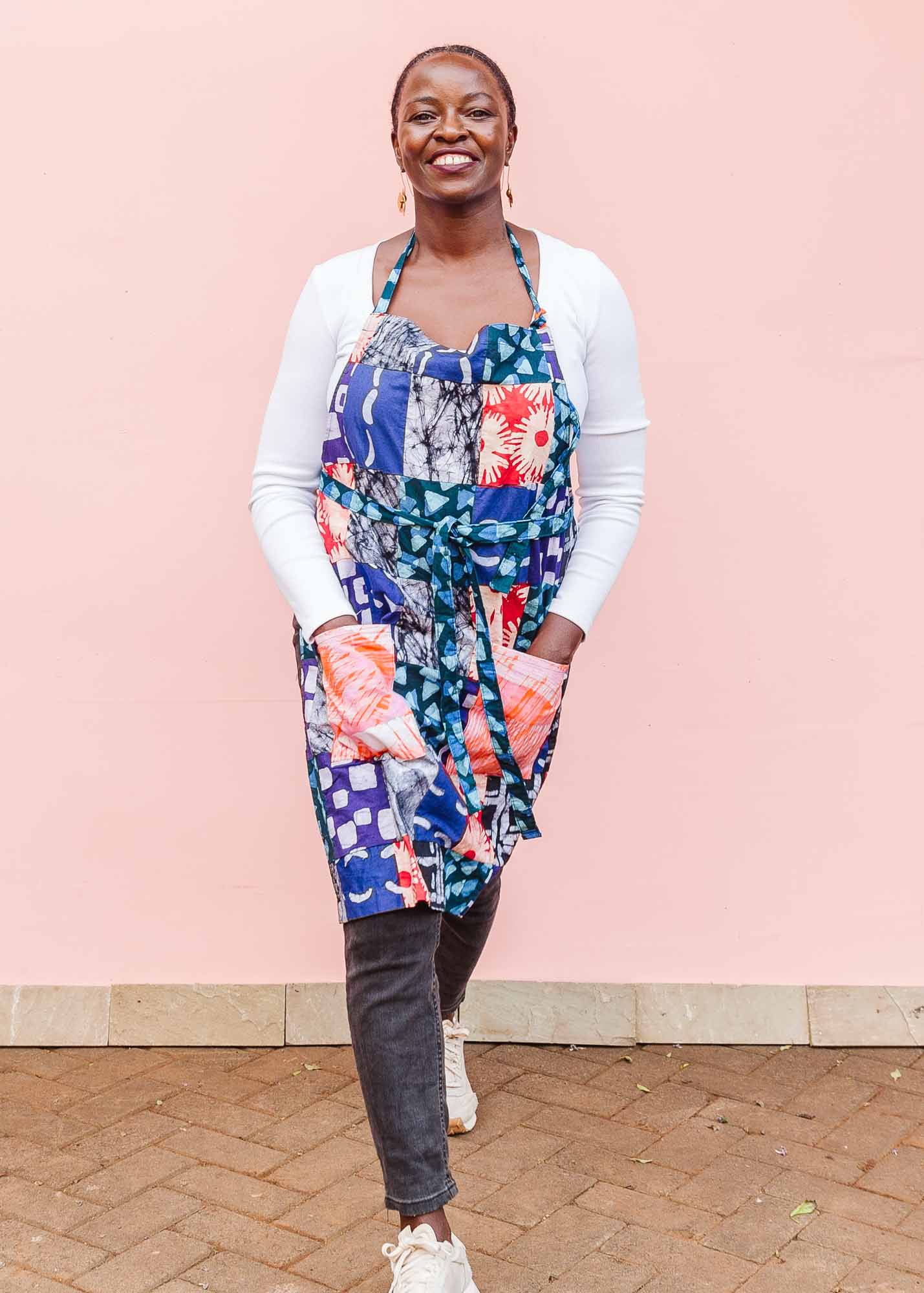 The model is wearing batik patchwork apron