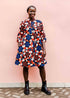 model wearing a blue, red, black and beige pinwheel design dress