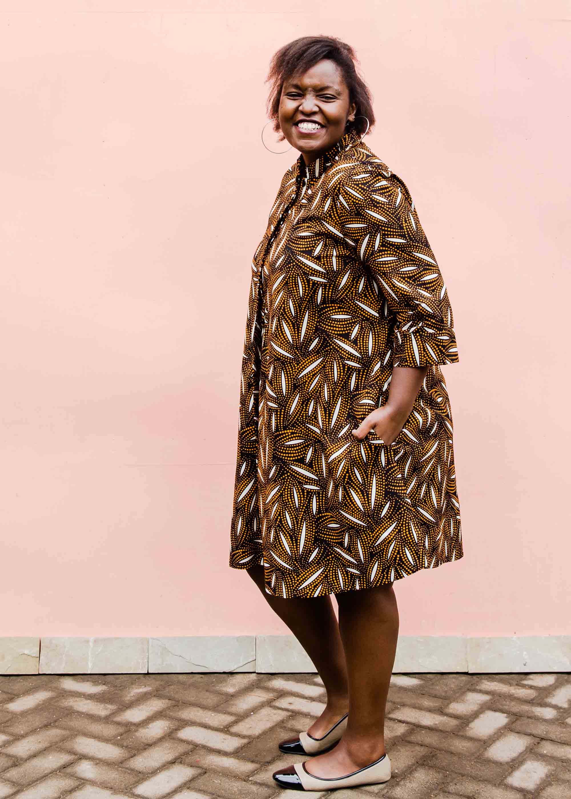 model wearing a brown, black and white seed design dress
