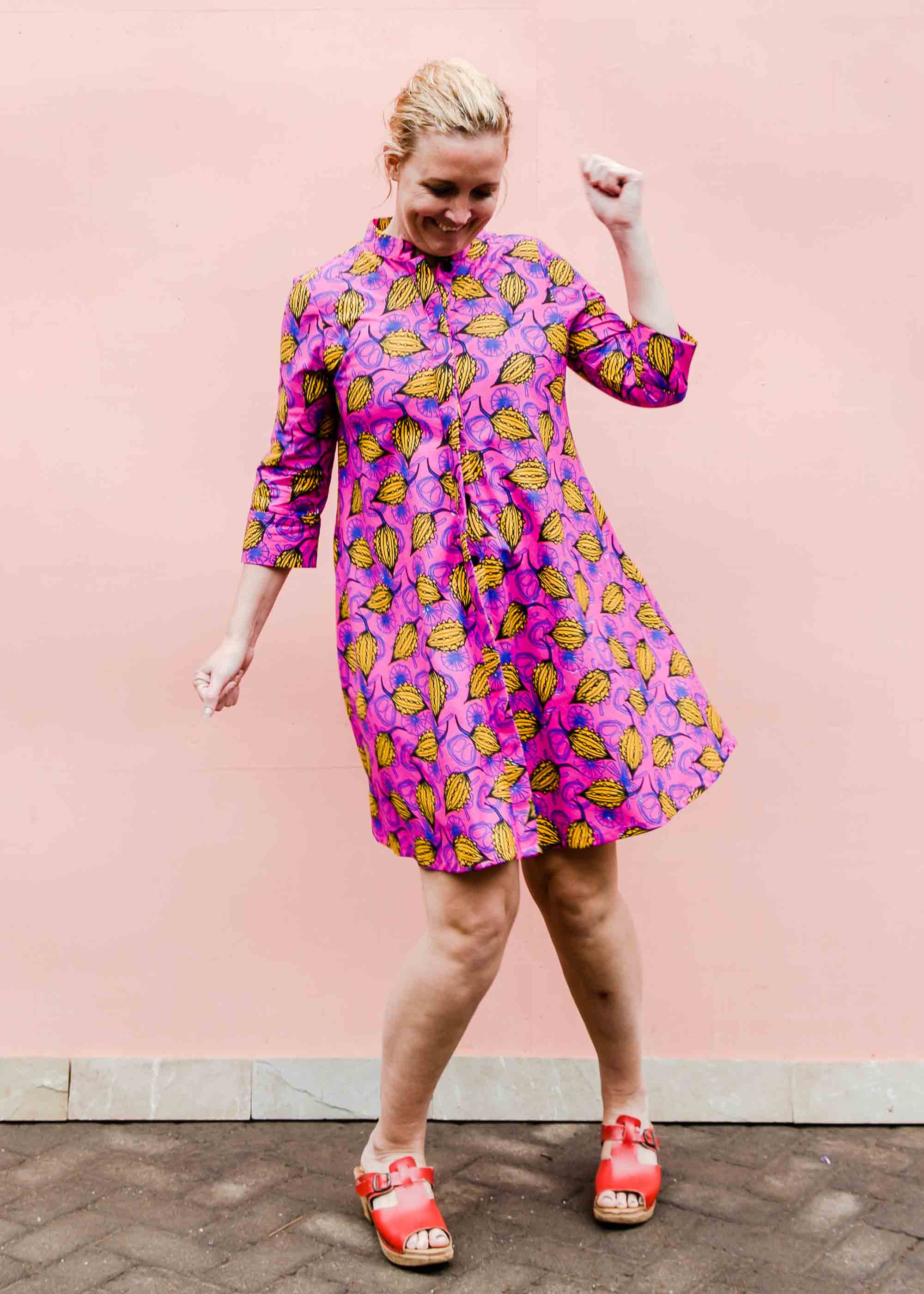 Model wearing pink dress with yellow seed design.