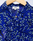 detail of a blue, light blue and black floral shirt dress