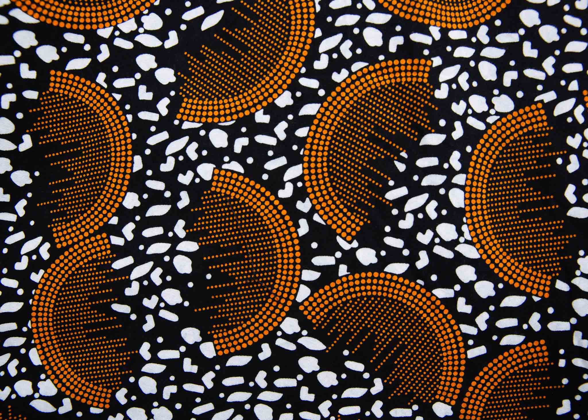 Display of black and white dress with orange half circle print.