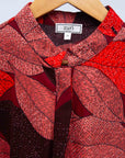 Display of red, brown, burgundy leaf print dress.