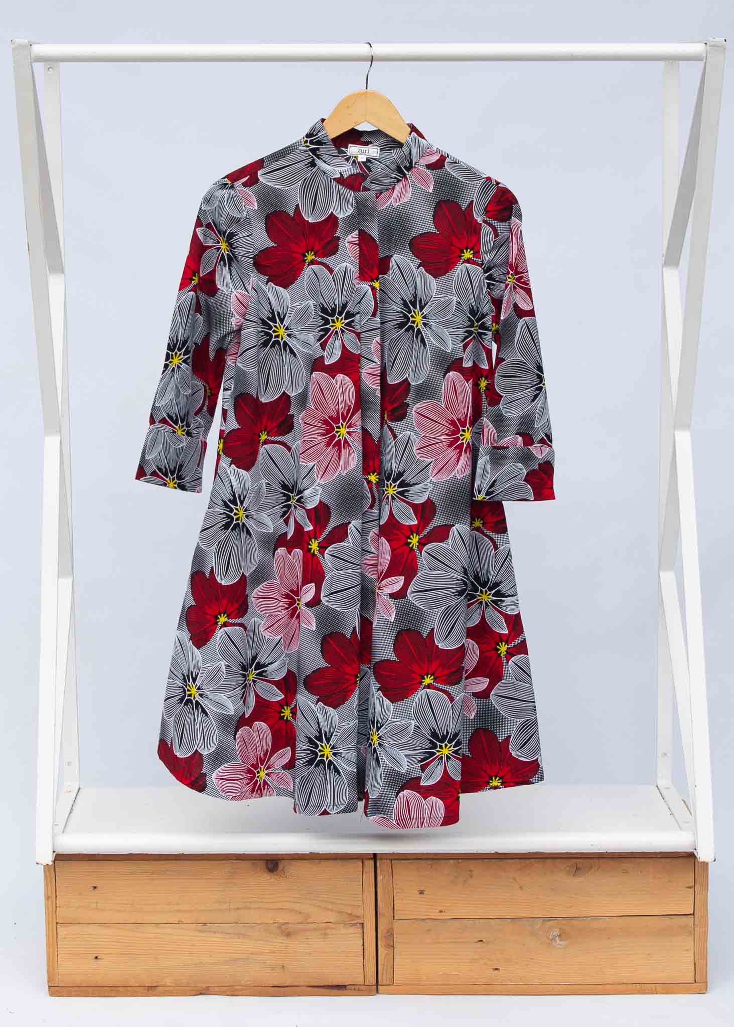 Display of dress with large grey and red flower print.