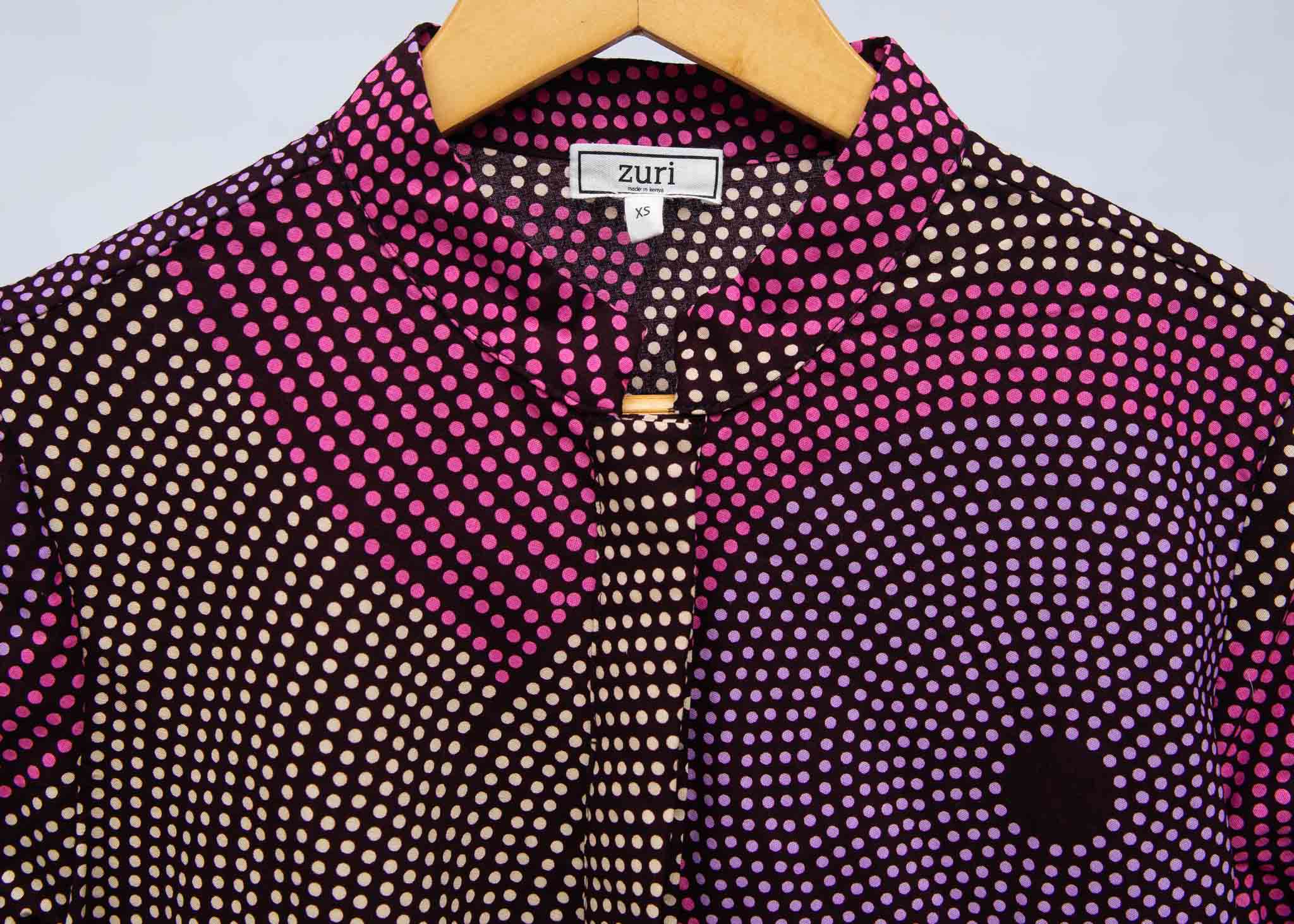 detail of a pink, purple, black and white shirt dress