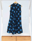 Display of black sleeveless dress with blue and white circle print.