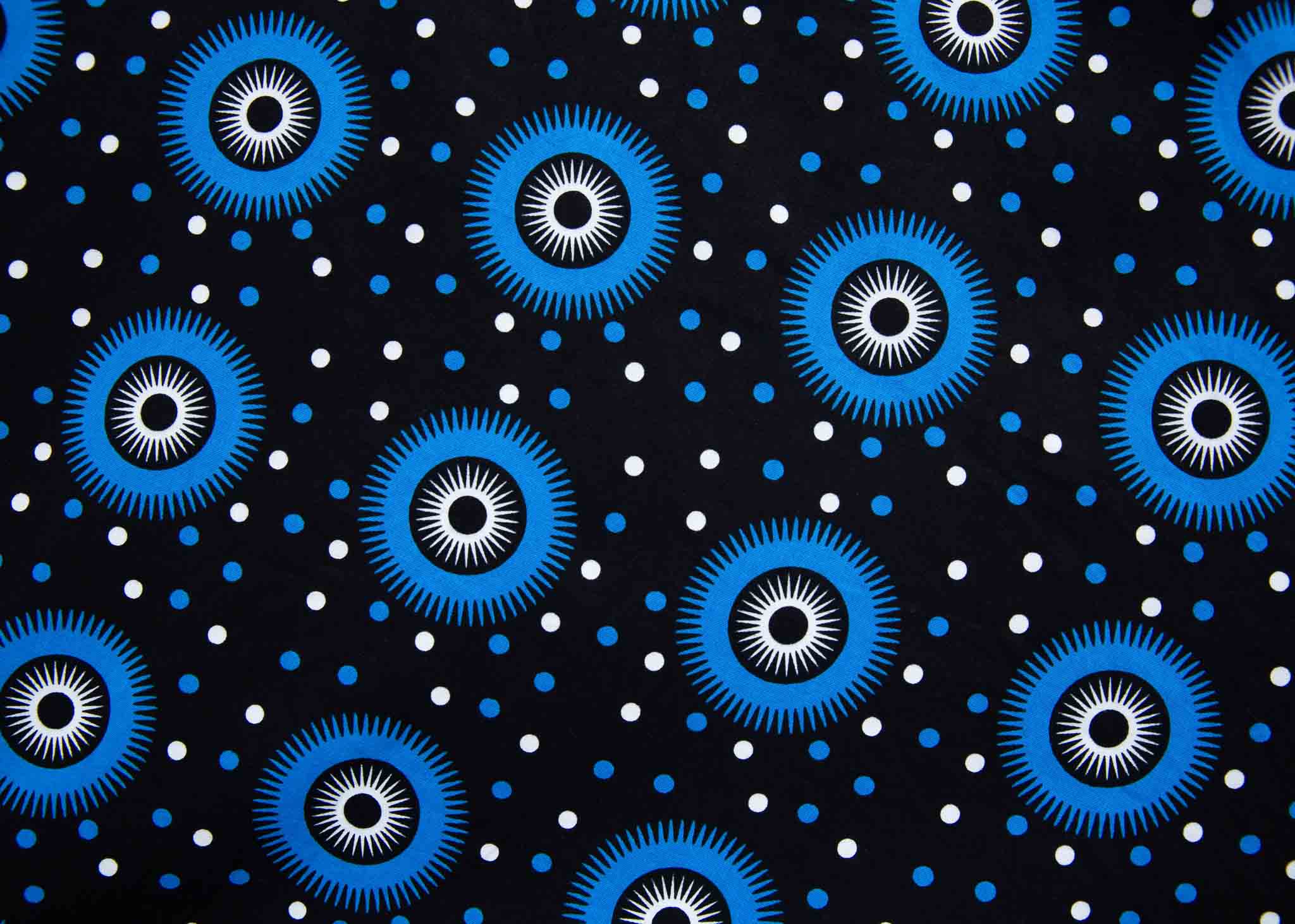 Display of black sleeveless dress with blue and white circle print.