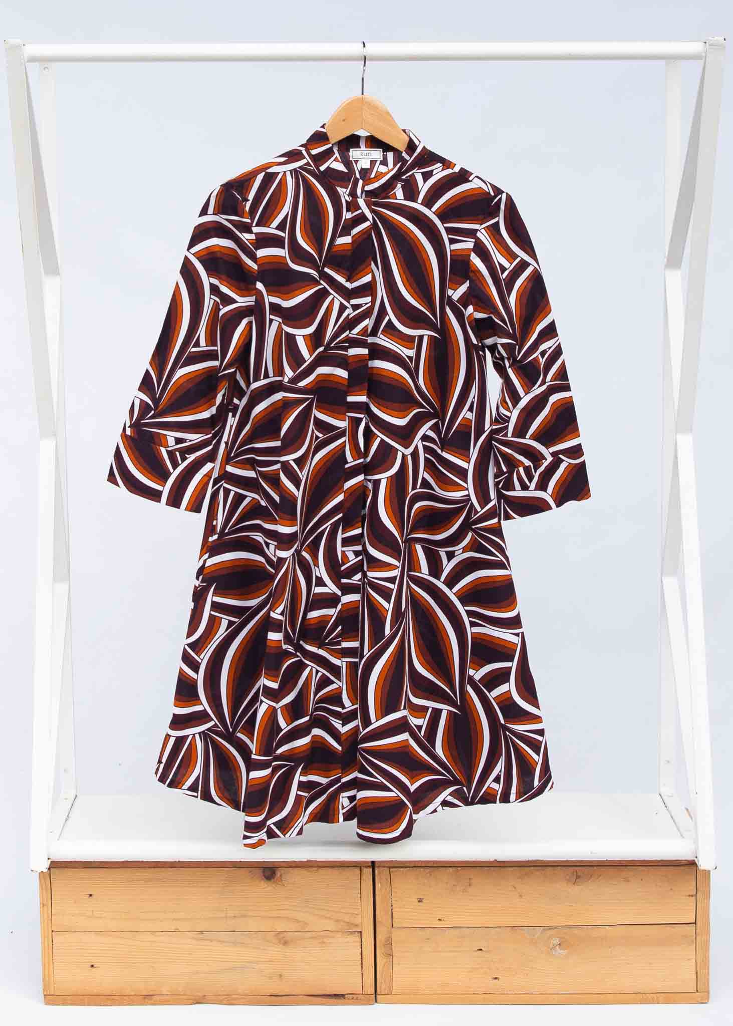 Display of brown, orange, burgundy and white abstract print dress.