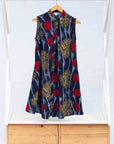 Display of navy sleeveless dress with red, yellow and white splatter print.