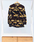 Display of long sleeve blouse with brown and yellow abstract print.