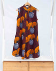 Display of burgundy sleeveless dress with yellow and white flowers.
