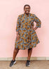 Model wearing black and white dress with orange half circle print.