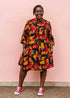 model wearing an orange, red and black floral shirt dress