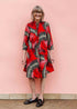 Model wearing red dress with black and white feather print.