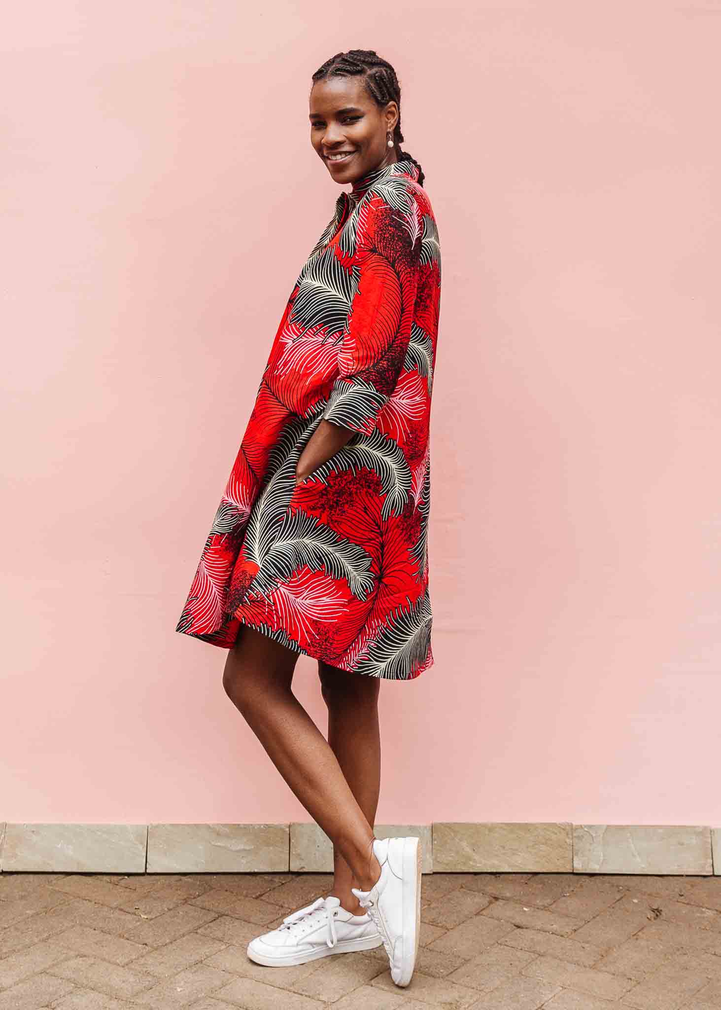 Model wearing red dress with black and white feather print.