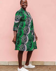 Model wearing green, white and black abstract print dress.