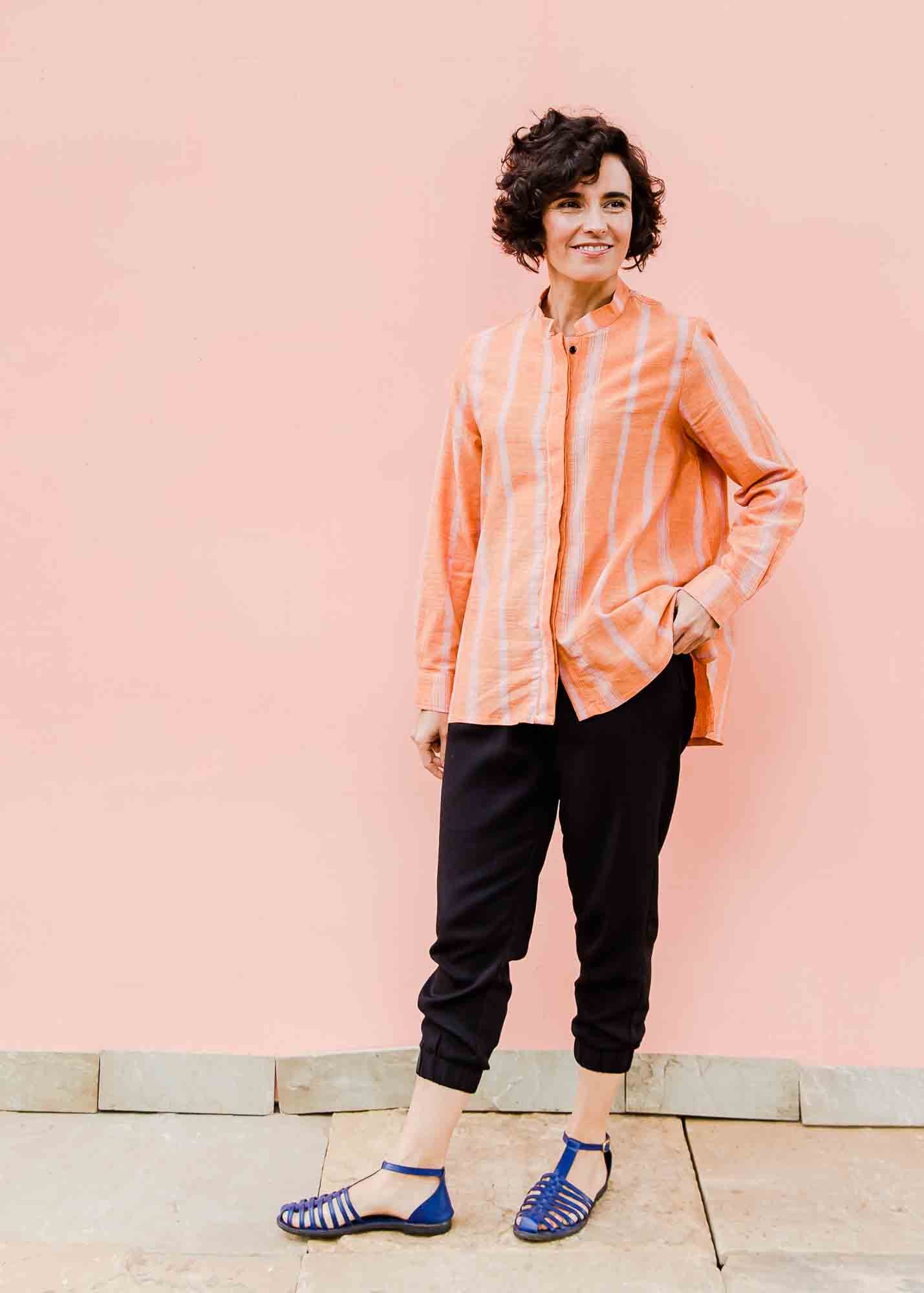 model wearing a peach and pink striped shirt