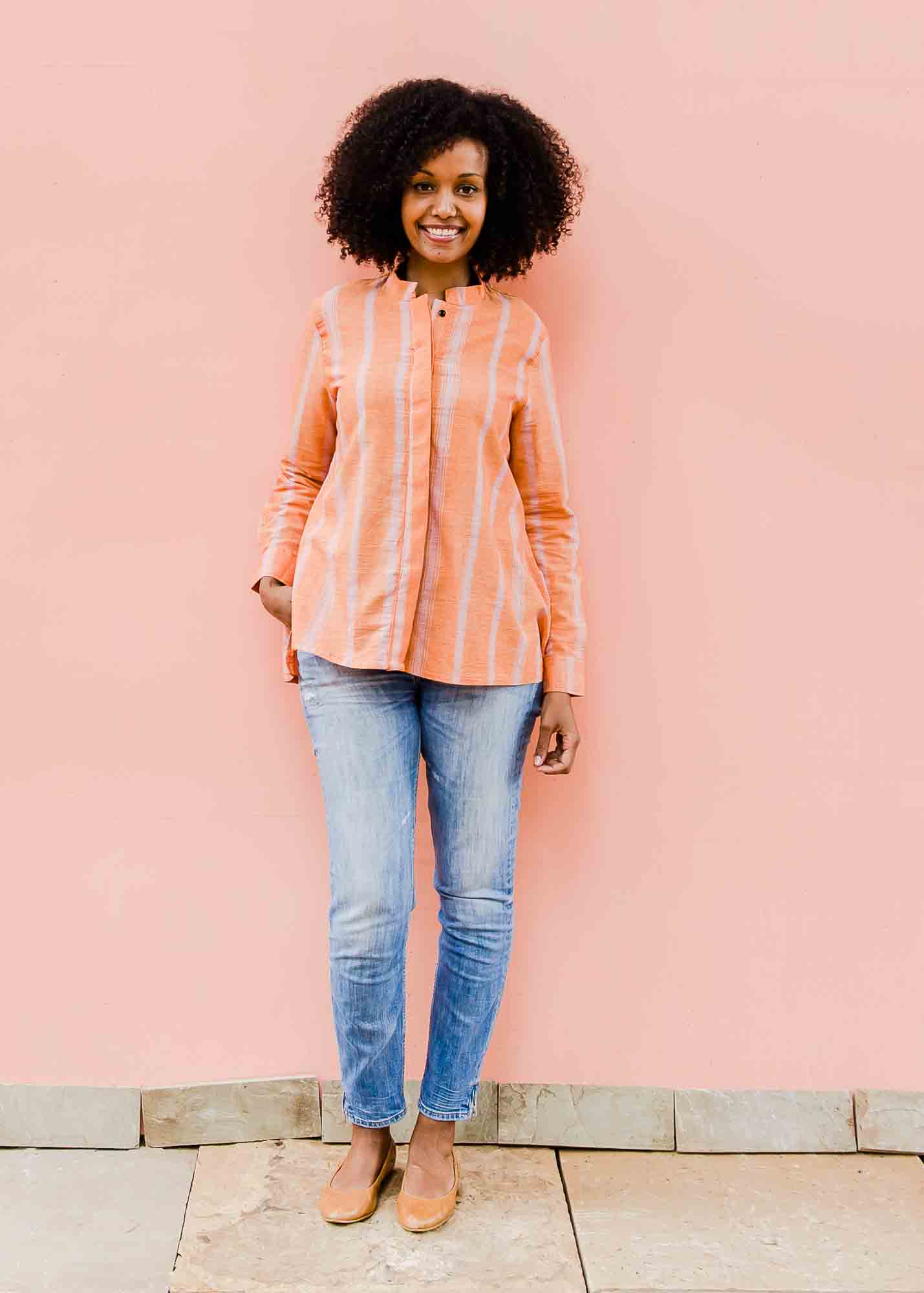model wearing a peach and pink striped shirt