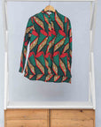 Display of green, red, black and brown scroll print long sleeve blouse.