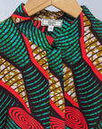 Display of green, red, black and brown scroll print long sleeve blouse.