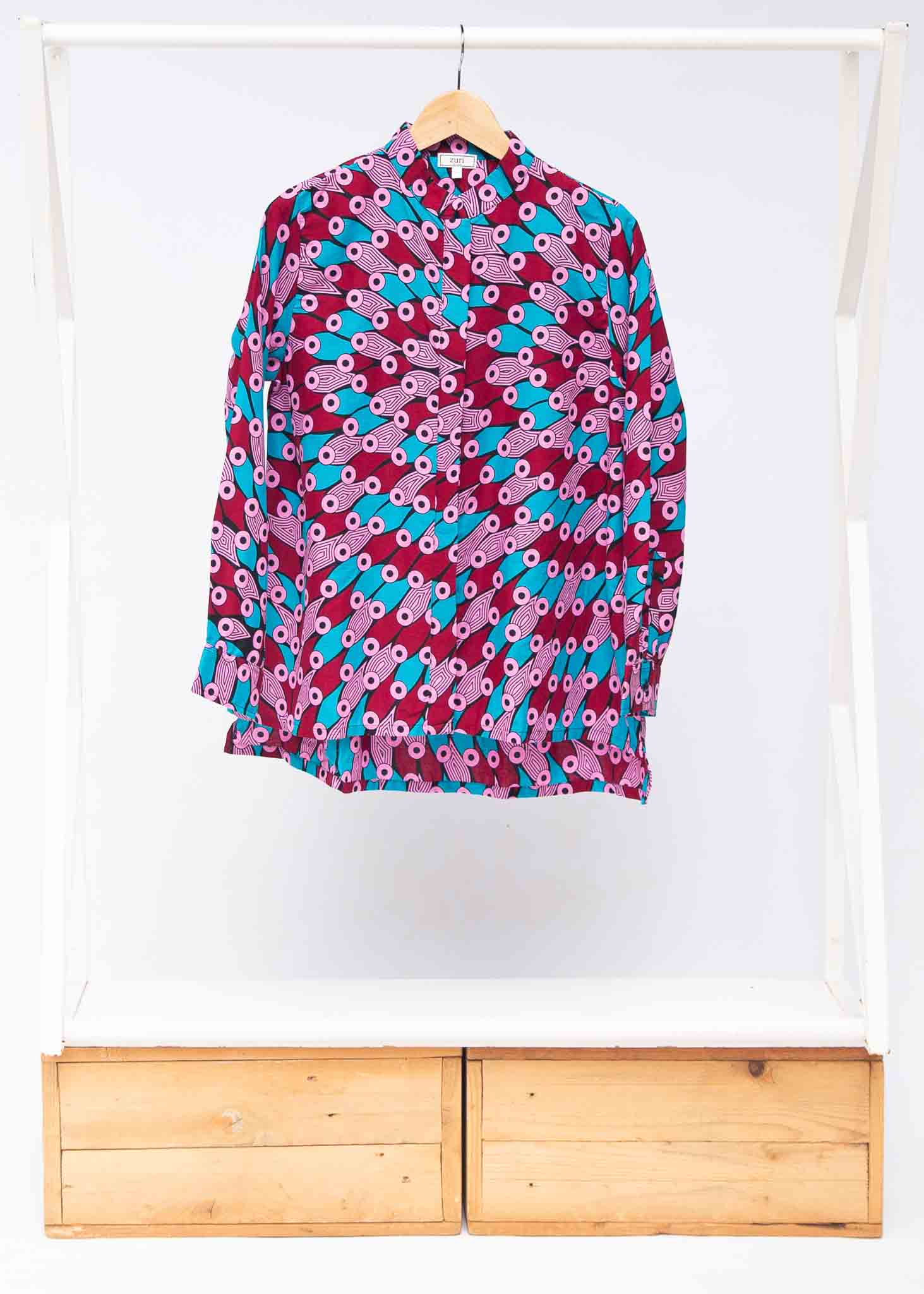 Display of pink, red, blue and black tube print long sleeve blouse.