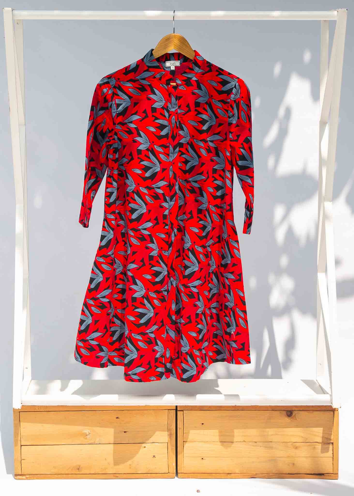 Display of red, black and gray leaf print dress.