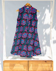 Display of black sleeveless dress with blue and pink poppy print.
