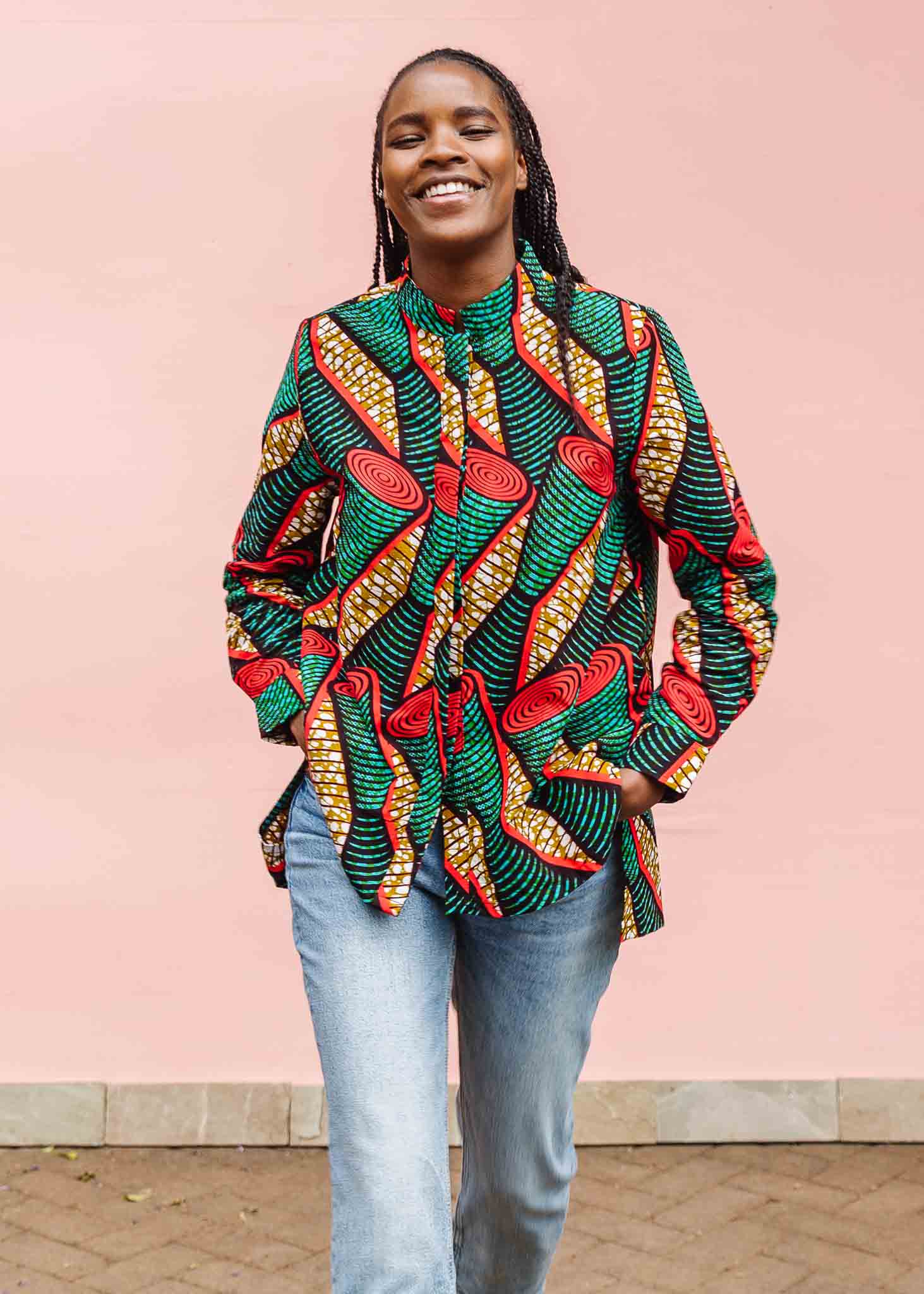 Model wearing green, red, black and brown scroll print long sleeve blouse.