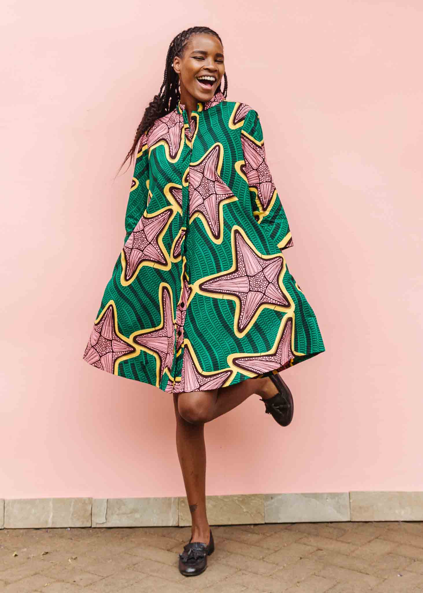 Model wearing green dress with brown and yellow star print.