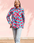 Model wearing pink, red, blue and black tube print long sleeve blouse.