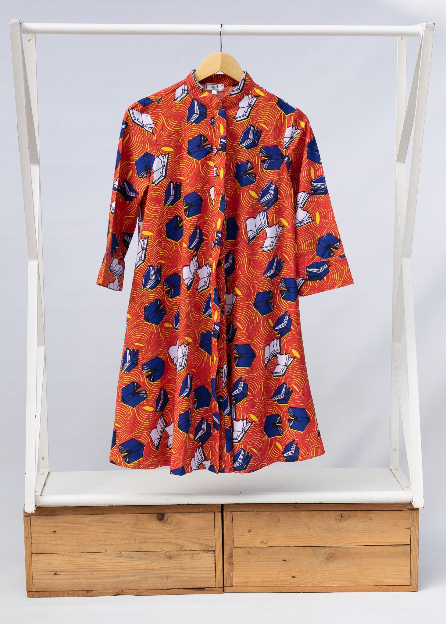 Display of yellow and red, blue book print dress.