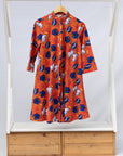 Display of yellow and red, blue book print dress.