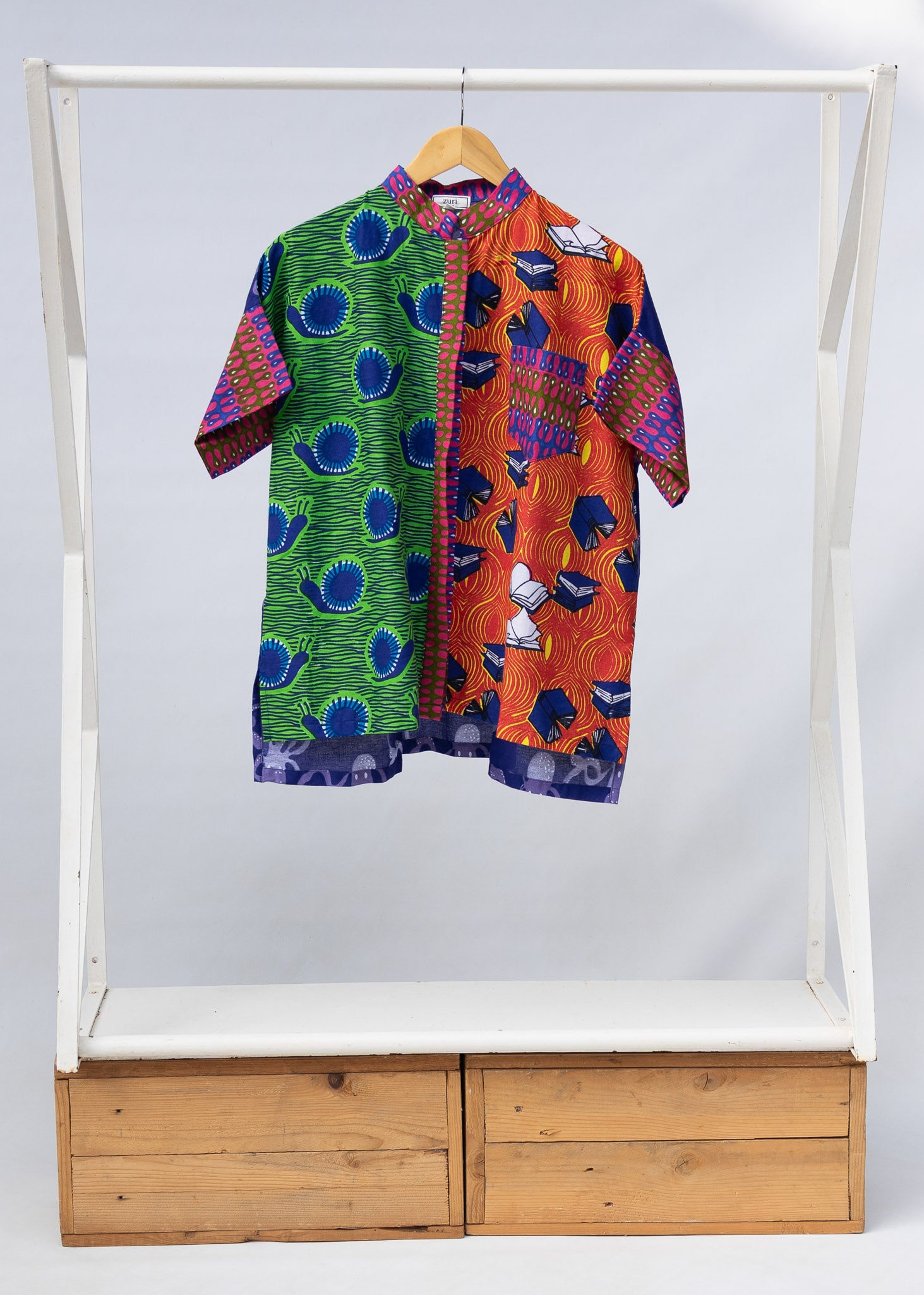 Display of green, orange and pink multiprint shirt.
