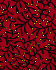 Close up display of red dress with small black and yellow branch design.