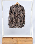 Display of black and beige abstract print blouse.