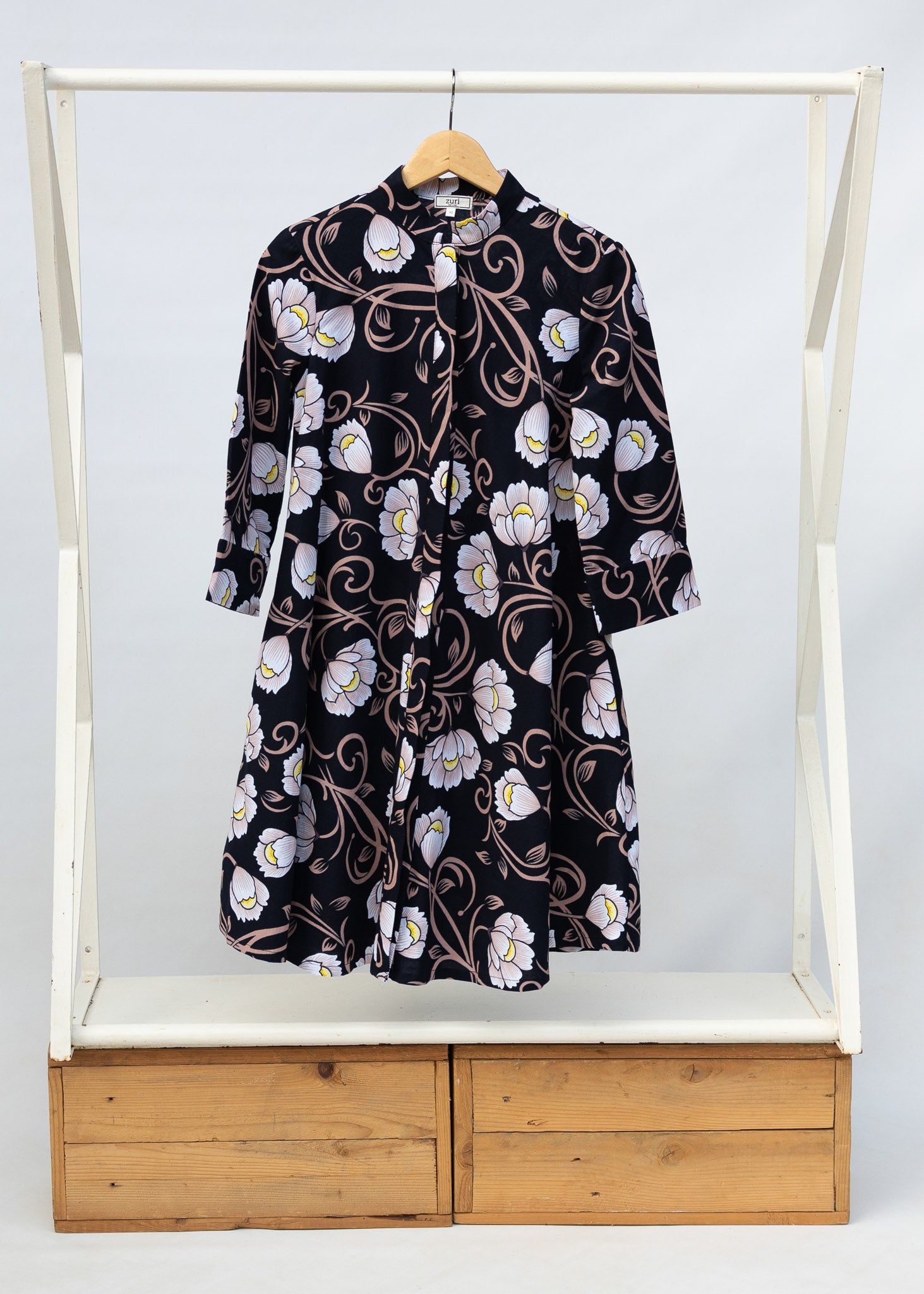 Display of black dress with pink and yellow floral print.