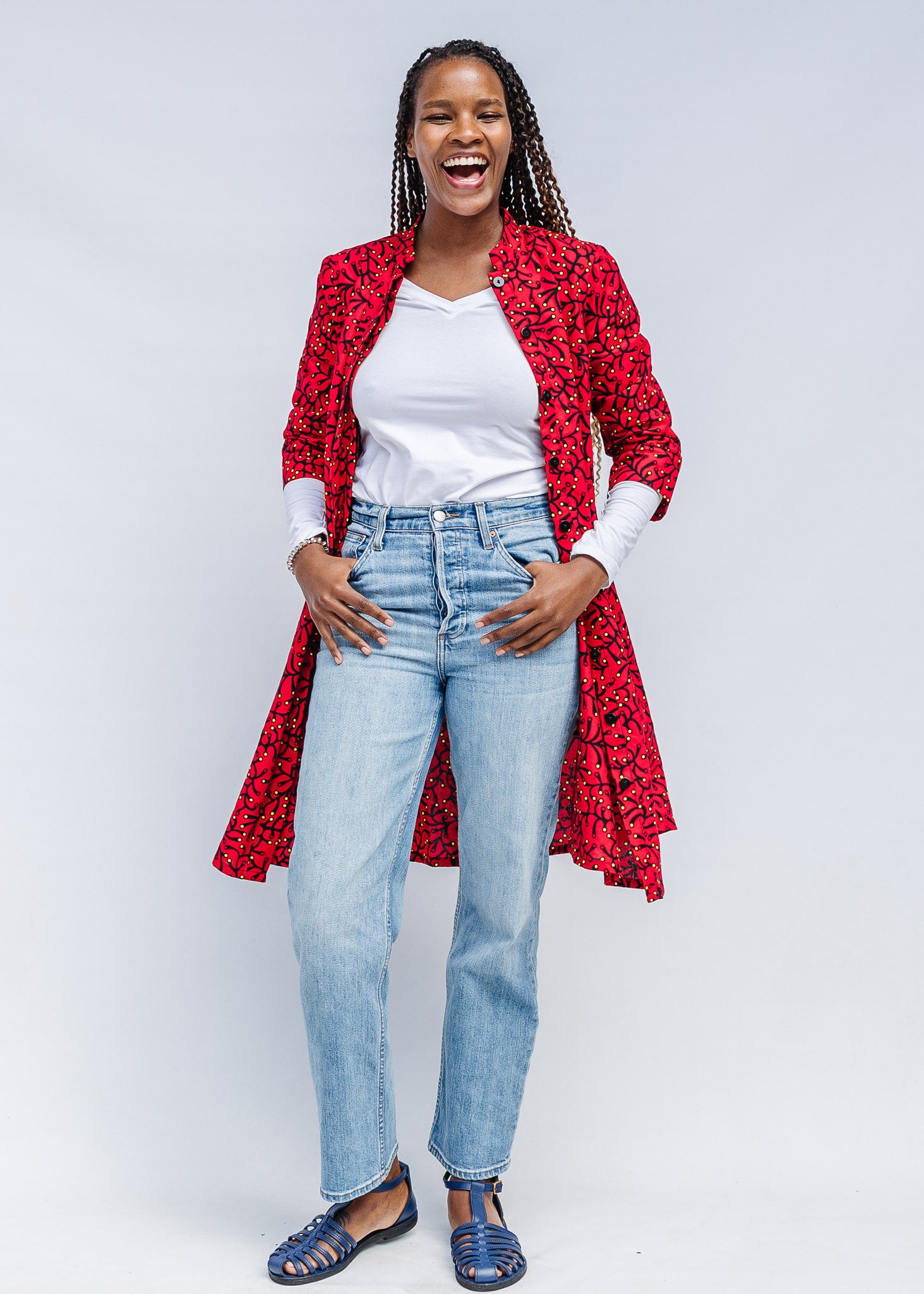 Model wearing red dress with small black and yellow branch design.