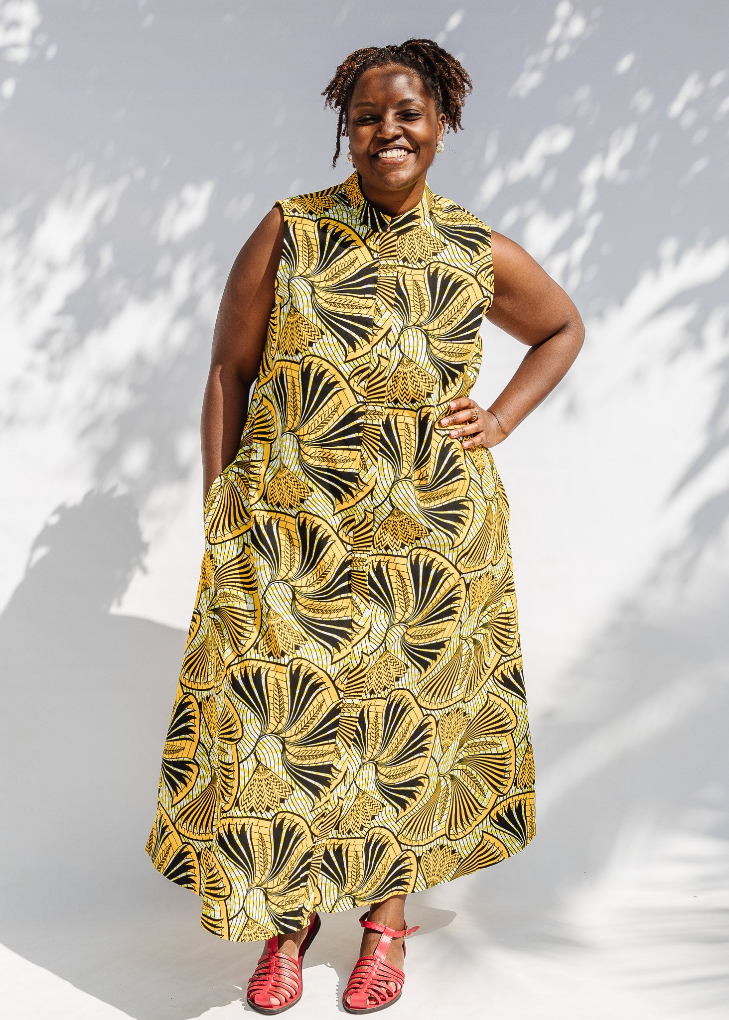 Model wearing yellow and black sleeveless maxi dress.