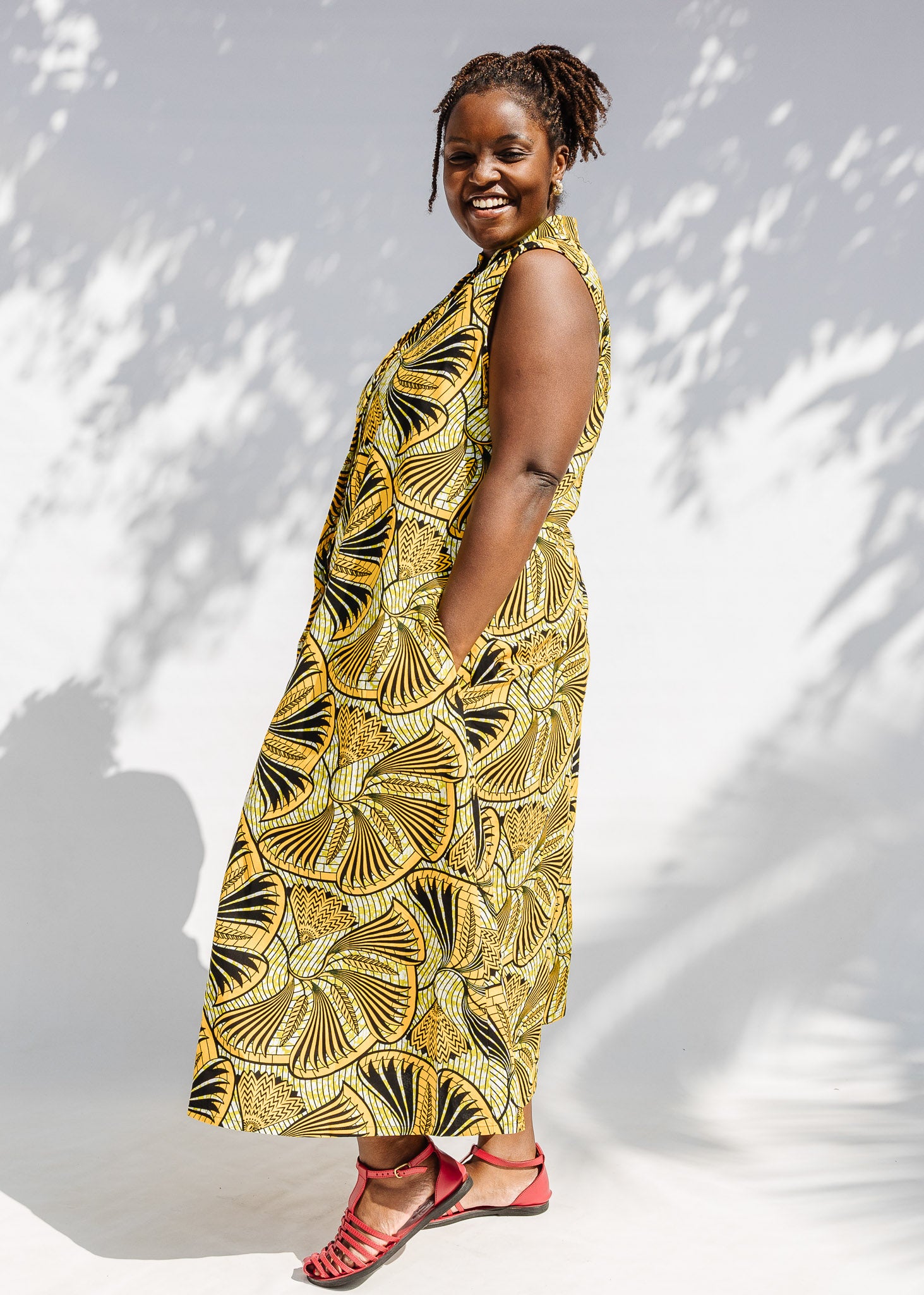 Model wearing yellow and black sleeveless maxi dress.