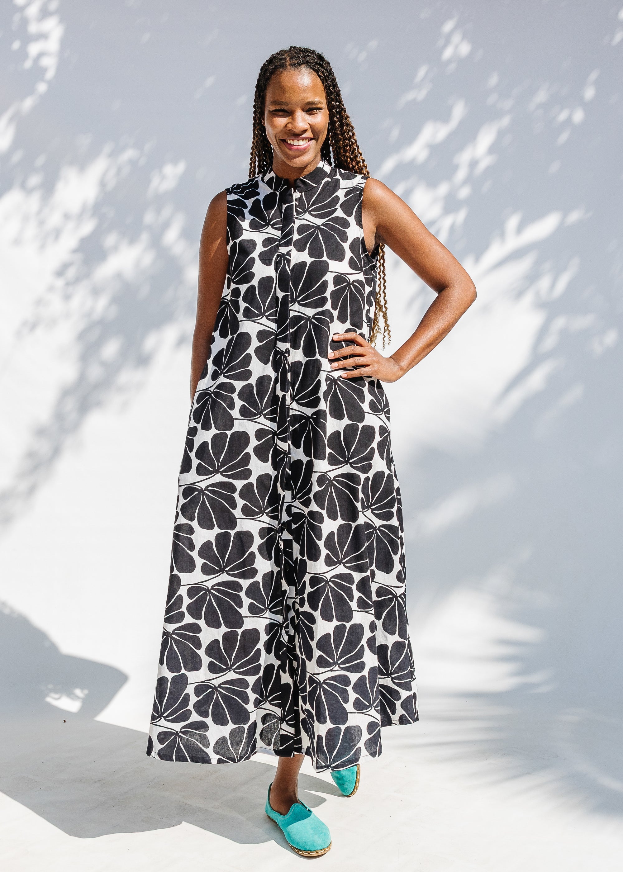 Model wearing black and white floral print, sleeveless dress.