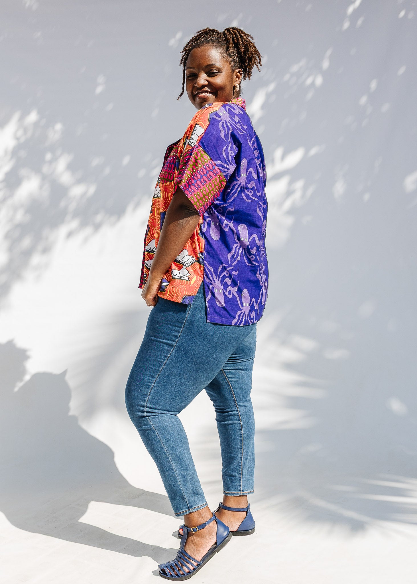 Model wearing green, orange and pink multiprint shirt.