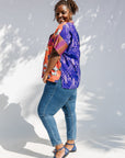 Model wearing green, orange and pink multiprint shirt.